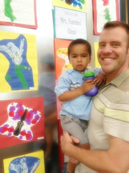 Nolin "proudly" showing off his Easter Lilly Painting at his school art show.